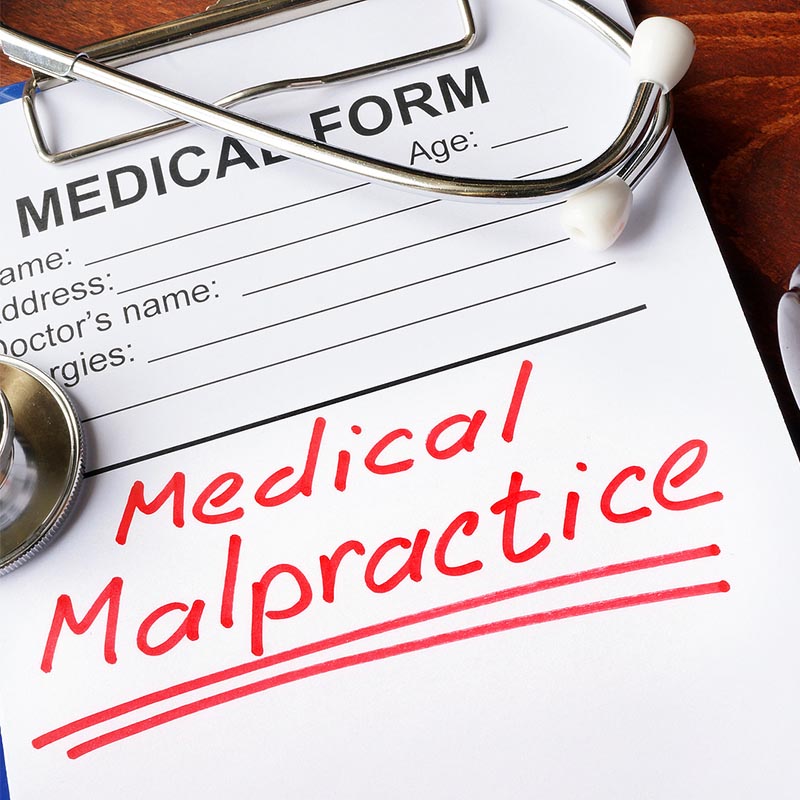Medical form with words Medical Malpractice and gavel